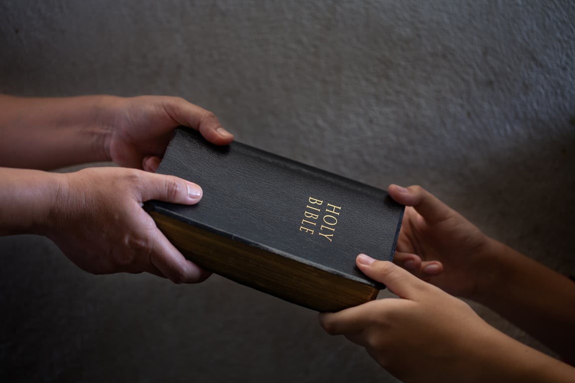 Handing Bible to Another Person